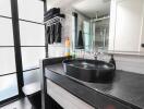 Modern bathroom with black countertop and round sink