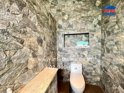 Bathroom with stone wall tiles and fitted shelf