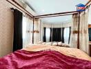 Elegantly decorated bedroom with canopy bed and large windows