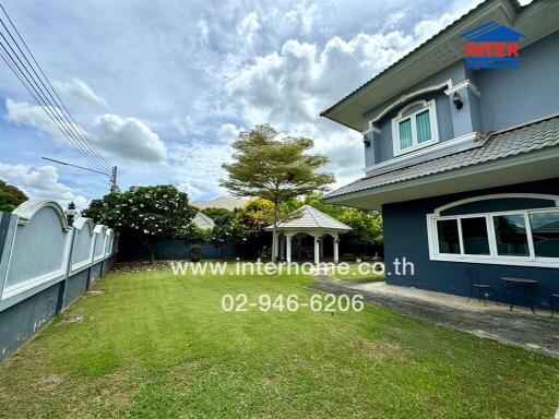 Spacious yard with a white gazebo and a two-story house