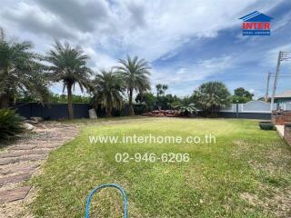 Spacious garden area with palm trees and well-maintained lawn