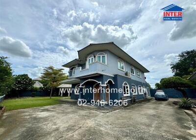 Two-story house with driveway and surrounding greenery