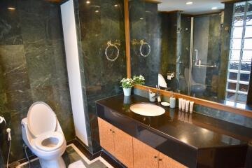 Spacious and modern bathroom with dark marble accents, large mirror, and vanity sink