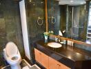 Spacious and modern bathroom with dark marble accents, large mirror, and vanity sink