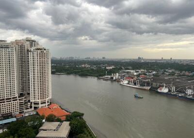 Riverside view with high-rise buildings and cloudy skies