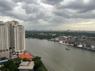 Riverside view with high-rise buildings and cloudy skies