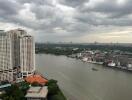 Riverside view with high-rise buildings and cloudy skies