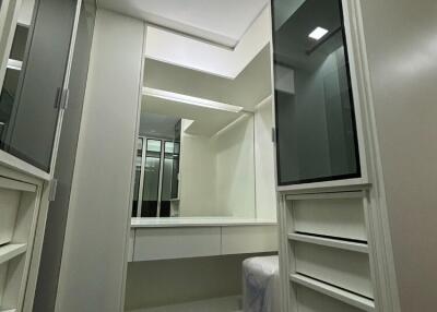 Spacious walk-in closet with built-in cabinets and mirrors