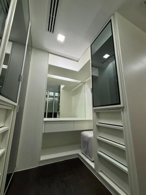 Spacious walk-in closet with built-in cabinets and mirrors