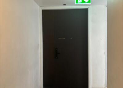 Main entrance of a building with a dark brown door and an emergency exit sign