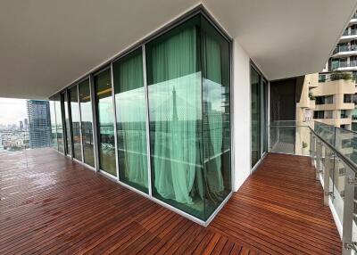 Spacious balcony with modern glass railings and city view