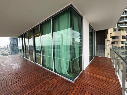 Spacious balcony with modern glass railings and city view