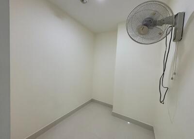 Small empty room with a wall-mounted fan and tile flooring