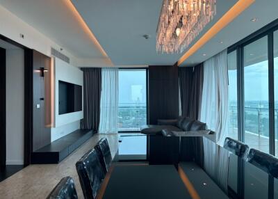 Modern living room with a large glass dining table and panoramic window views