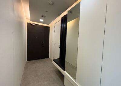 hallway with a mirror and dark door