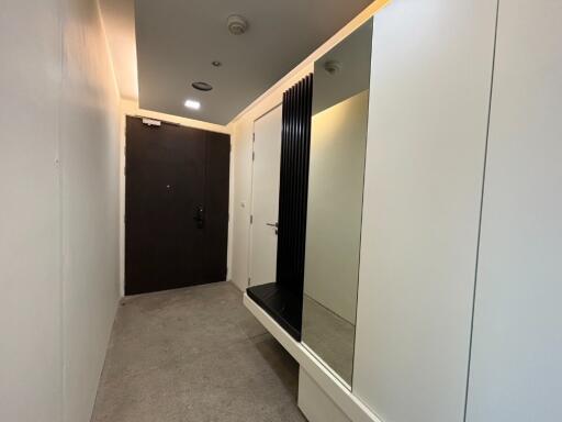 hallway with a mirror and dark door