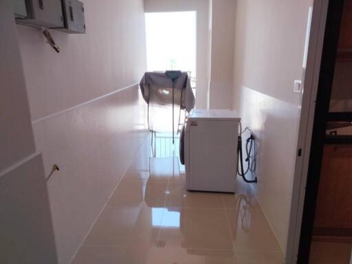 Clean and spacious laundry area with tile floors and washing machine