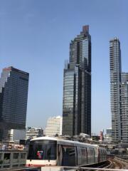 View of modern high-rise buildings and a train on the tracks in a city