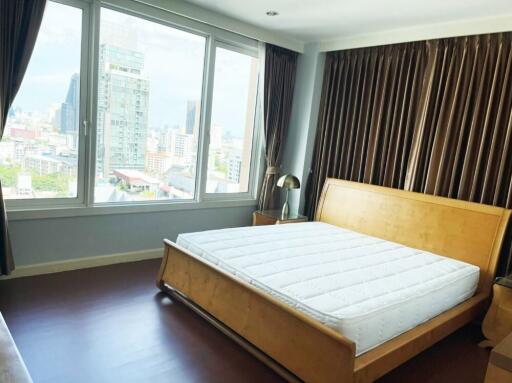 Bedroom with bed, large window, and city view