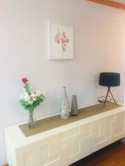 Decorative sideboard with flower vase and table lamp