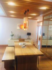 Modern dining room with wooden table and bench, pendant lights, and decorative elements