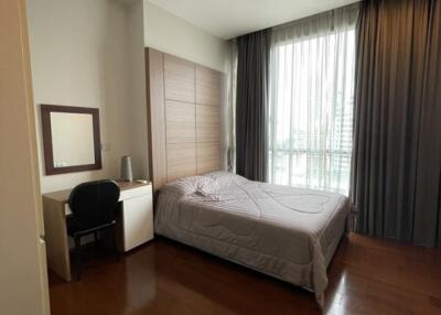 Bedroom with bed, desk, chair, mirror, and large window