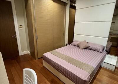 Modern bedroom with wooden flooring and closet