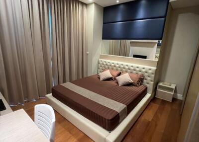 Modern bedroom with wooden flooring, large windows, double bed, desk, and ample lighting.