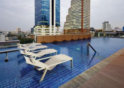 Rooftop swimming pool with lounge chairs and city view