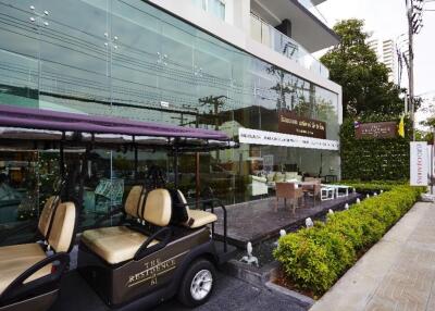 Front entrance of a modern residential building with outdoor seating and golf cart