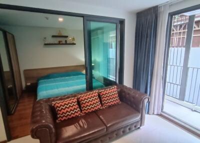 Bedroom with outside view and a brown leather sofa