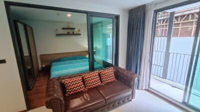 Bedroom with outside view and a brown leather sofa