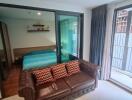 Bedroom with outside view and a brown leather sofa