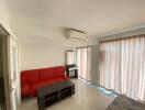 Living room with red couch, air conditioner, and large windows