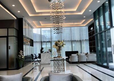 Modern lobby with seating and a decorative chandelier