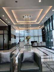 Modern lobby with seating and a decorative chandelier