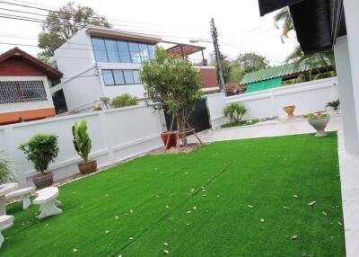 Well-maintained backyard with artificial grass and potted plants