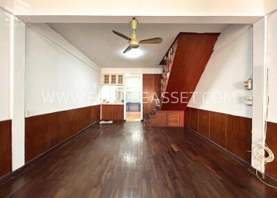 Open living area with wooden flooring and staircase