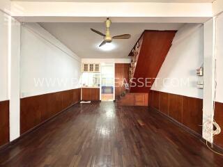 Open living area with wooden flooring and staircase