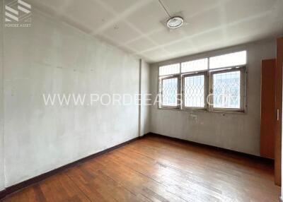 Empty bedroom with large windows and wooden floor