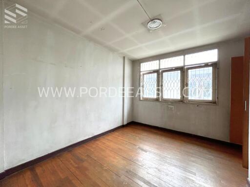 Empty bedroom with large windows and wooden floor