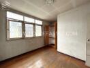 Empty bedroom with wooden floors and a built-in closet