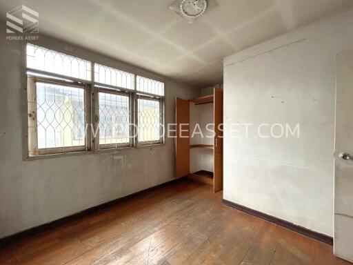 Empty bedroom with wooden floors and a built-in closet