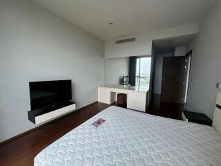 Modern bedroom with TV, desk, and large bed