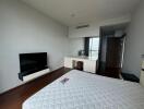 Modern bedroom with TV, desk, and large bed