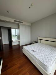 Modern bedroom with wooden floors and large windows