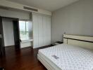 Modern bedroom with wooden floors and large windows