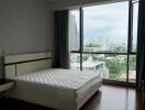 Bedroom with large window and city view