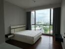 Modern bedroom with large window and city view