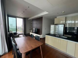 Modern main living area with dining table, sofa, TV, and kitchen